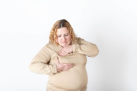 Plus size woman doing a Breast Self-Exam (BSE)