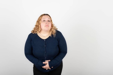 Woman with stomach ache on white background