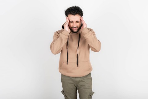 Stressed and tired man touches his head because of a headache