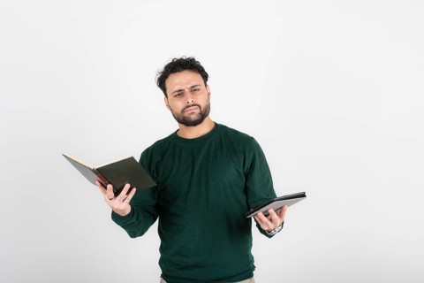 Thoughtful man holding a book in one hand and an e-reader in the other