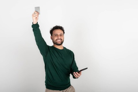 Happy man celebrating an online purchase with his credit card