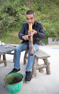 Vietnamese man smoking a thick bamboo pipe, Ha Giang province, Vietnam, Asia
