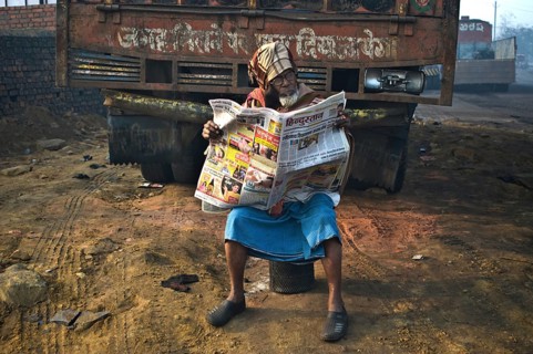 Muslim man reading the newspaper in the street (Dhanbad, Jharkhand, India) . The newspaper is