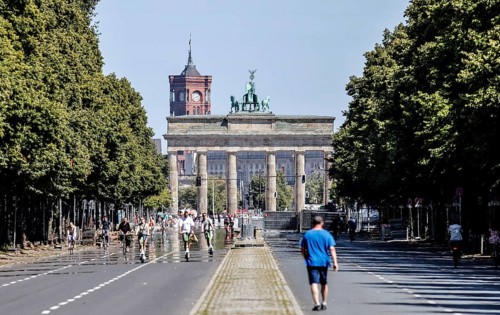 Pedestrians, cyclists and e-scooters on the road on the Strasse des 17 Juni at the Brandenburg Tor,
