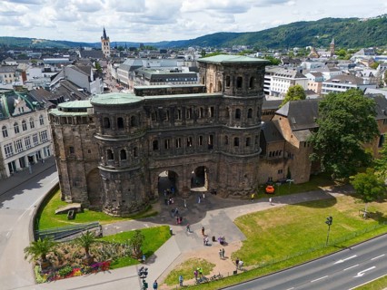 Historical architecture of the Porta Nigra with city panorama, surrounded by mountains and green