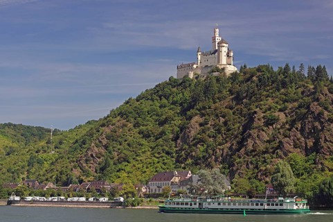A castle on a green hill, on the bank of a river, with a ship in the foreground, Middle Ages,
