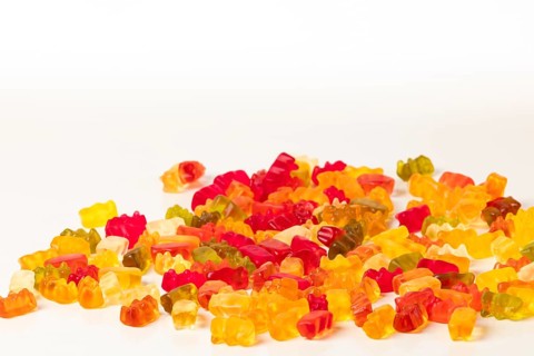 Group of different coloured gummy bears, on white, copying room