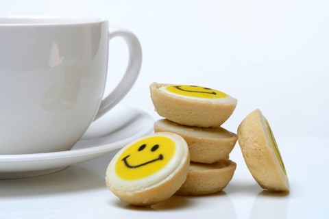 Pastry with smiley face and coffee cup, symbol