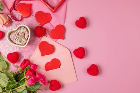 Heart-shaped cupcake, red hearts and roses around an envelope, Valentine's Day, pink background
