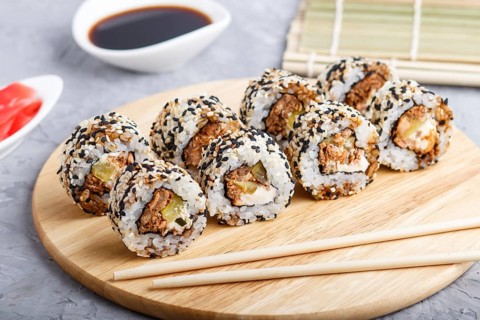 Japanese maki sushi rolls with salmon, sesame, cucumber chopsticks, soy sauce and marinated ginger