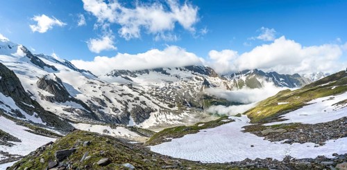 Mountain landscape with snow fields and high fog in the valley, summit Hoher WeiÃŸzint and