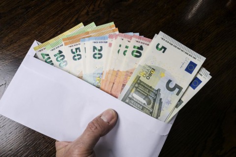 Envelope full of money, symbolic photo of pay packet, bribery
