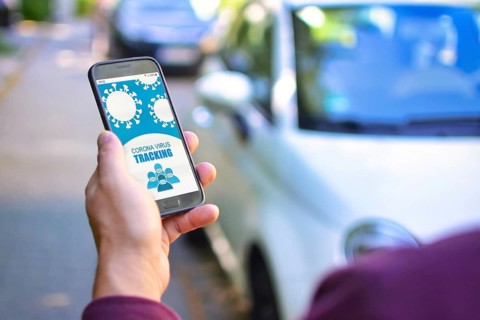 Corona Virus Tracking App concept with hand holding cell phone with application design on screen in