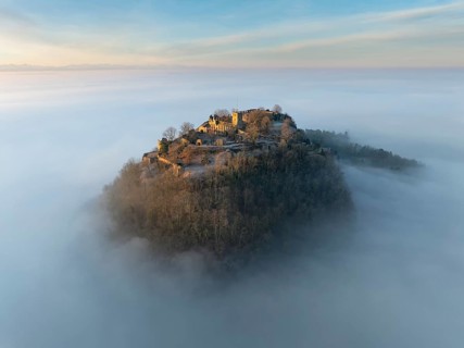 Aerial view of the Hegau volcano Hohentwiel with the upper fortress ruins illuminated by the rising