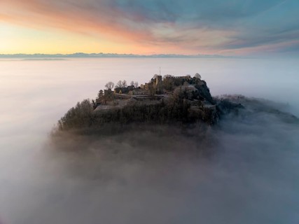 Aerial view of the Hegau volcano Hohentwiel with the upper fortress ruins in front of sunrise,