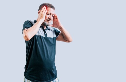 Senior man with headache isolated. Senior person with migraine holding his head isolated