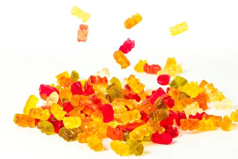 Different coloured gummy bears, falling, on white