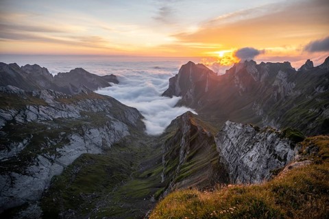 View over SÃ¤ntis mountains into the valley of Meglisalp at sunrise, high fog in the valley,