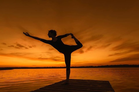 Woman practicing yoga posture Natarajasana, Lord of the Dance Pose, one legged standing, balancing,
