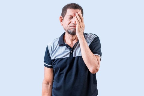 Tired and exhausted old man covering his face with the palm of his hand. Exhausted senior man
