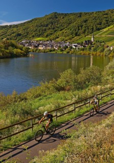 Cyclists on the Moselle cycle path with a view of the village of Bremm, Rhineland-Palatinate,