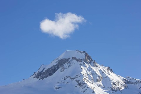 White cloud over snow covered mountain top, pinnacle Ciarforon in winter in the Gran Paradiso