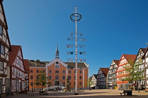Market square with maypole and town hall in the historic old town with many half-timbered houses,