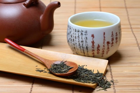 Green Sencha tea in tea bowl and tea leaves in wooden spoon, green tea, Japan, Asia