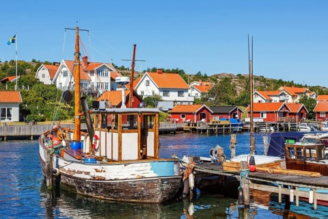 Old fishing boat at a jetty in a fishing village harbour on the Swedish west coast on a sunny