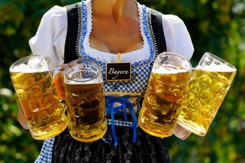 A waitress in a dirndl serves four litres of beer in a beer mug, Oktoberfest, Munich, Germany,