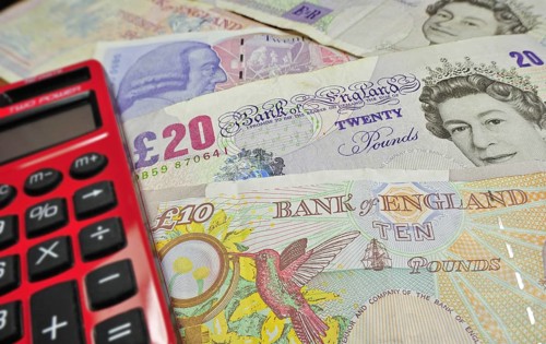 English banknotes in pound sterling and pocket calculator