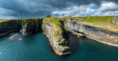 Aerial panorama of the ruined Castle of Old Wick surrounded by rugged cliffs on the North Sea