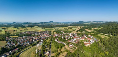 Aerial panorama of the town of Aach im Hegau, with the Hegauberge mountains on the horizon,