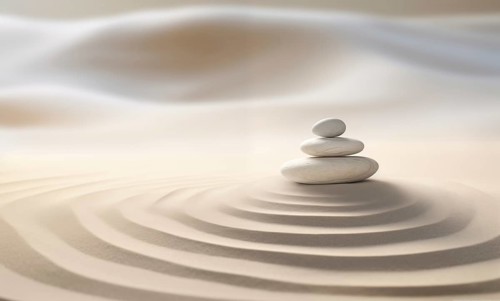 Zen stones stack on raked sand in a minimalist setting for balance and harmony. Balance, harmony,