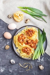 Tagliatelle bolognese pasta with minced meat on a black concrete background. top view, flat lay