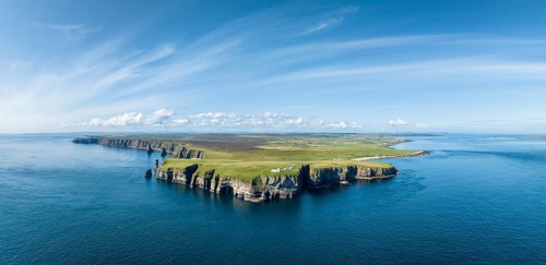 Aerial panorama of the rugged coastal landscape at Duncansby Head with the lighthouse, Duncansby