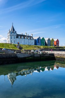 Holiday homes reflected in the ferry harbour of John o' Groats, County Caithness, Scotland, United