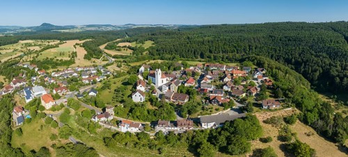 Aerial panorama of the town of Aach im Hegau, with the Hegauberge mountains on the horizon,