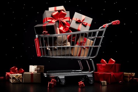 A black Friday Sale concept, black present boxes with red ribbons in shopping cart on a black