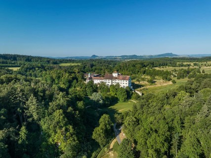 Aerial view of Langenstein Castle near Eigeltingen with surrounding golf course, on the horizon the