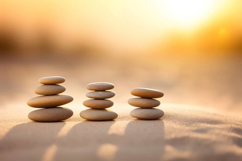 Zen stones stack on sand waves in a minimalist setting for balance and harmony. Balance, harmony,