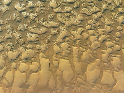 Sandy shapes at low tide at the shore of the Atlantic Ocean near Cape Trafalgar. Aerial view. Drone