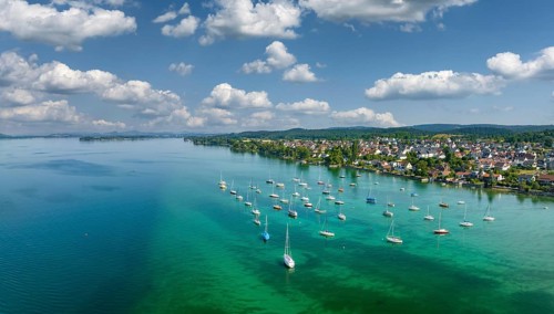 Aerial panorama of Lake Constance and the village of Allensbach, sailing boats parked in the shore