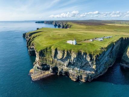 Aerial view of the rugged coastal landscape at Duncansby Head with the lighthouse and the Duncansby
