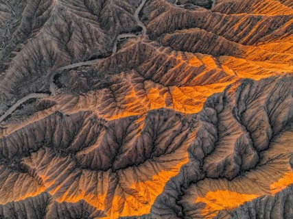 Landscape of eroded hills at Lake Issyk Kul, top-down, badlands at sunrise, aerial view, Canyon of