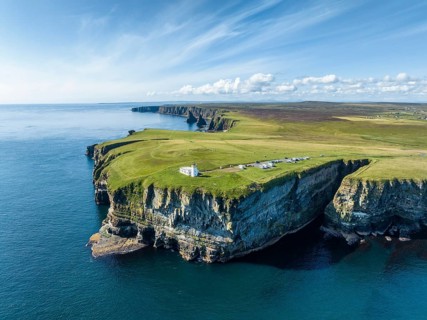 Aerial view of the rugged coastal landscape at Duncansby Head with the lighthouse and the Duncansby