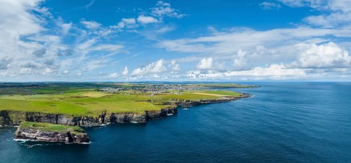 Aerial panorama of rugged cliffs on the North Sea coast, with the harbour town of Wick on the