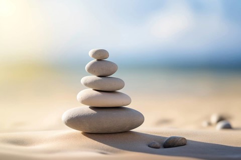 Zen stones stack on sand waves in a minimalist setting for balance and harmony. Balance, harmony,
