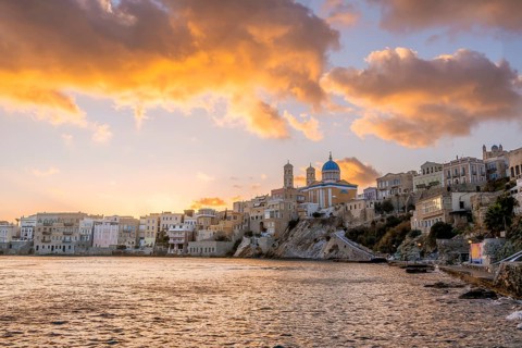 View of the village with the Greek Orthodox church of Agios Nikolaos, Asteria Beach, at sunset with