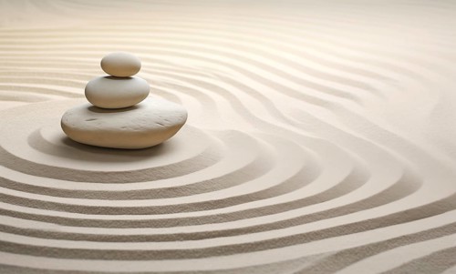Zen stones stack on raked sand waves in a minimalist setting for balance and harmony. Balance,